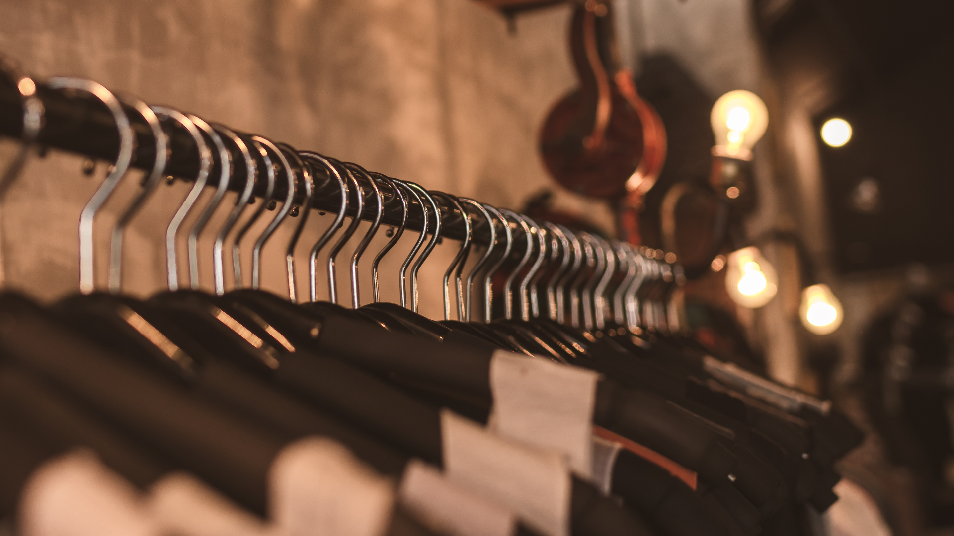 A row of clothes hanging on a rack in a store.