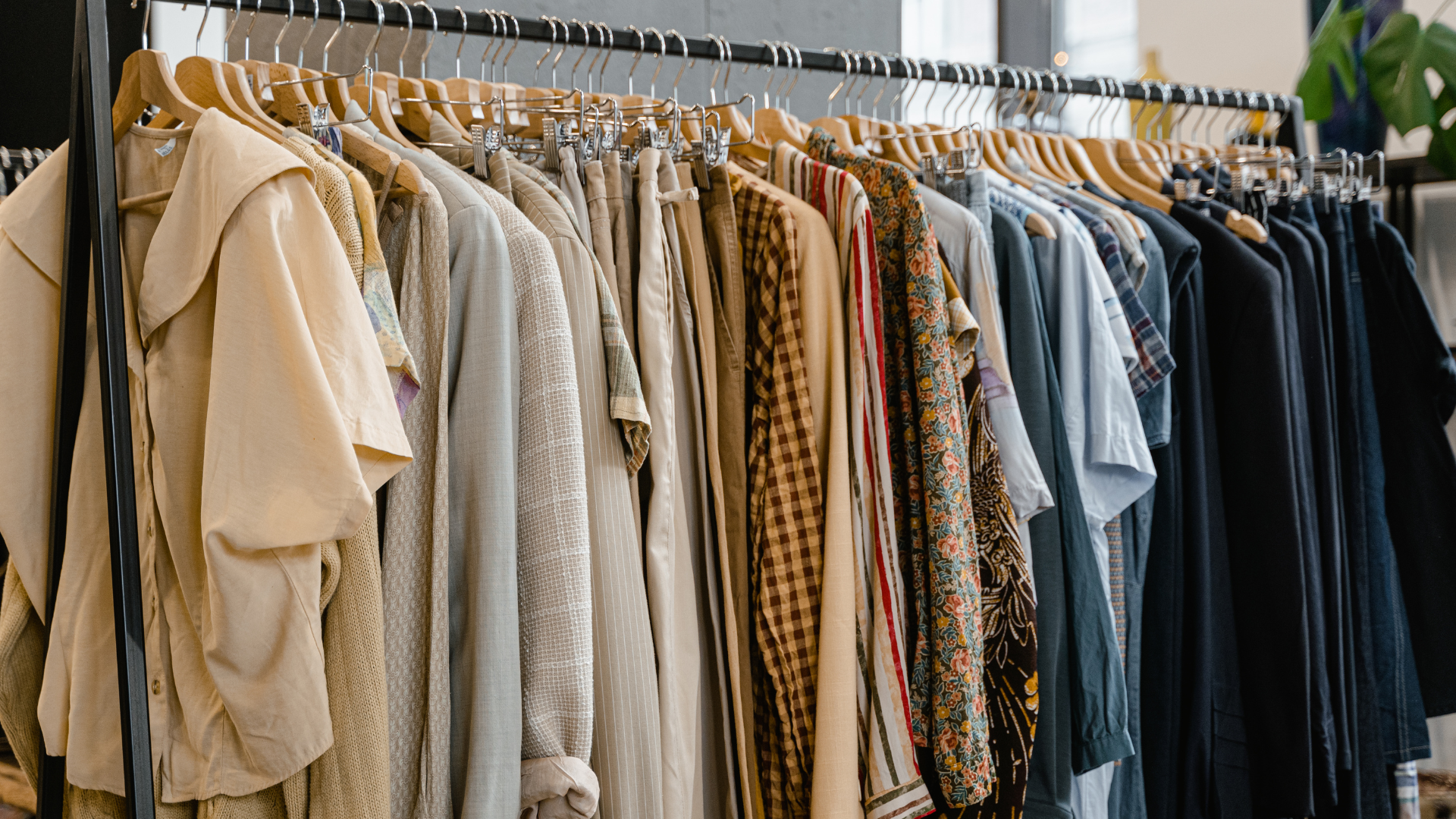 A row of clothes hanging on a rack in a store.