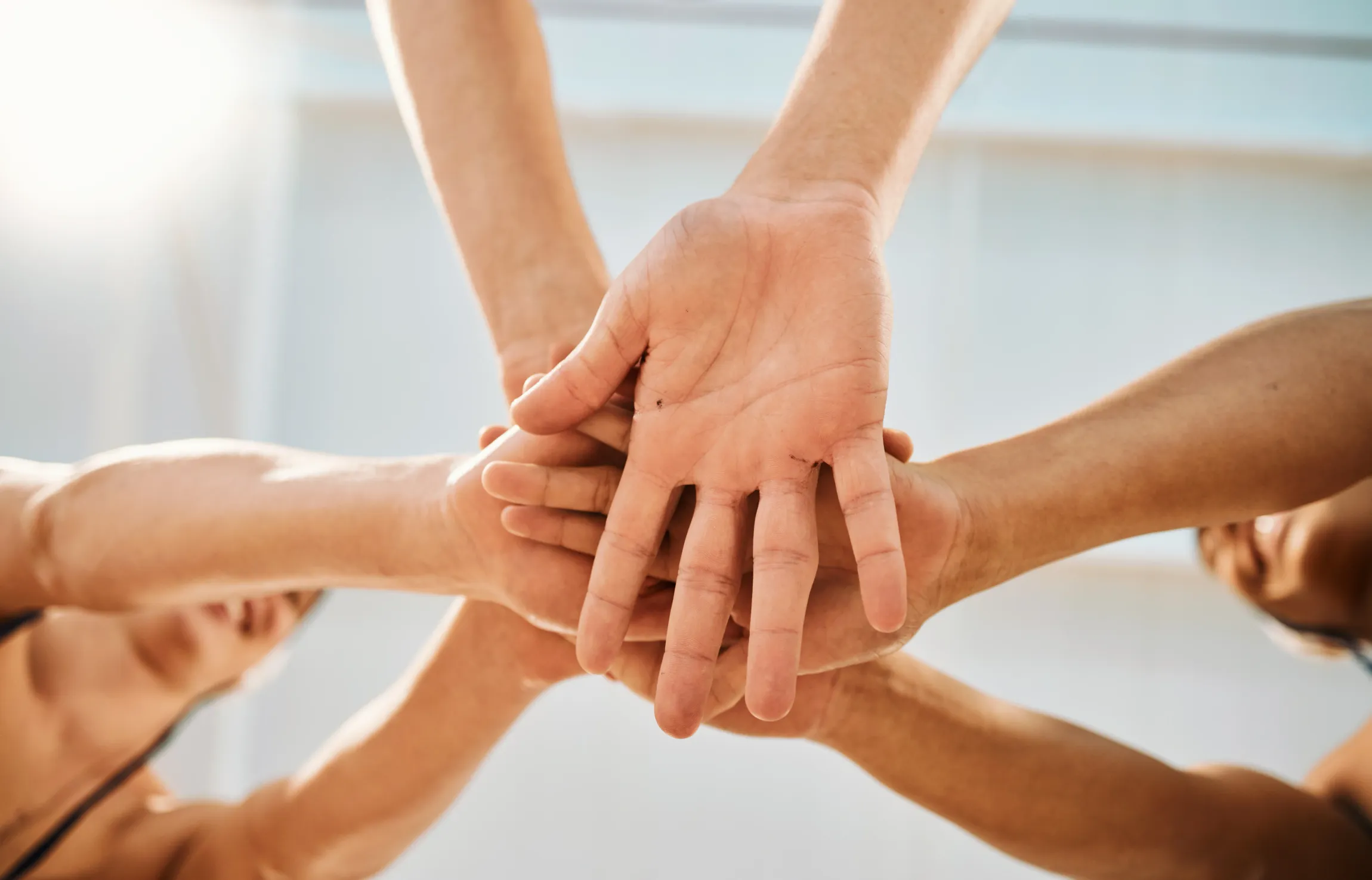 Hands stacked together in a symbol of teamwork and unity.