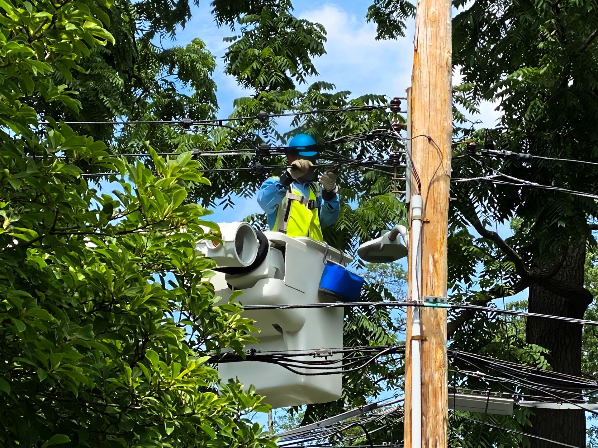 A man in a bucket is working on a power line.
