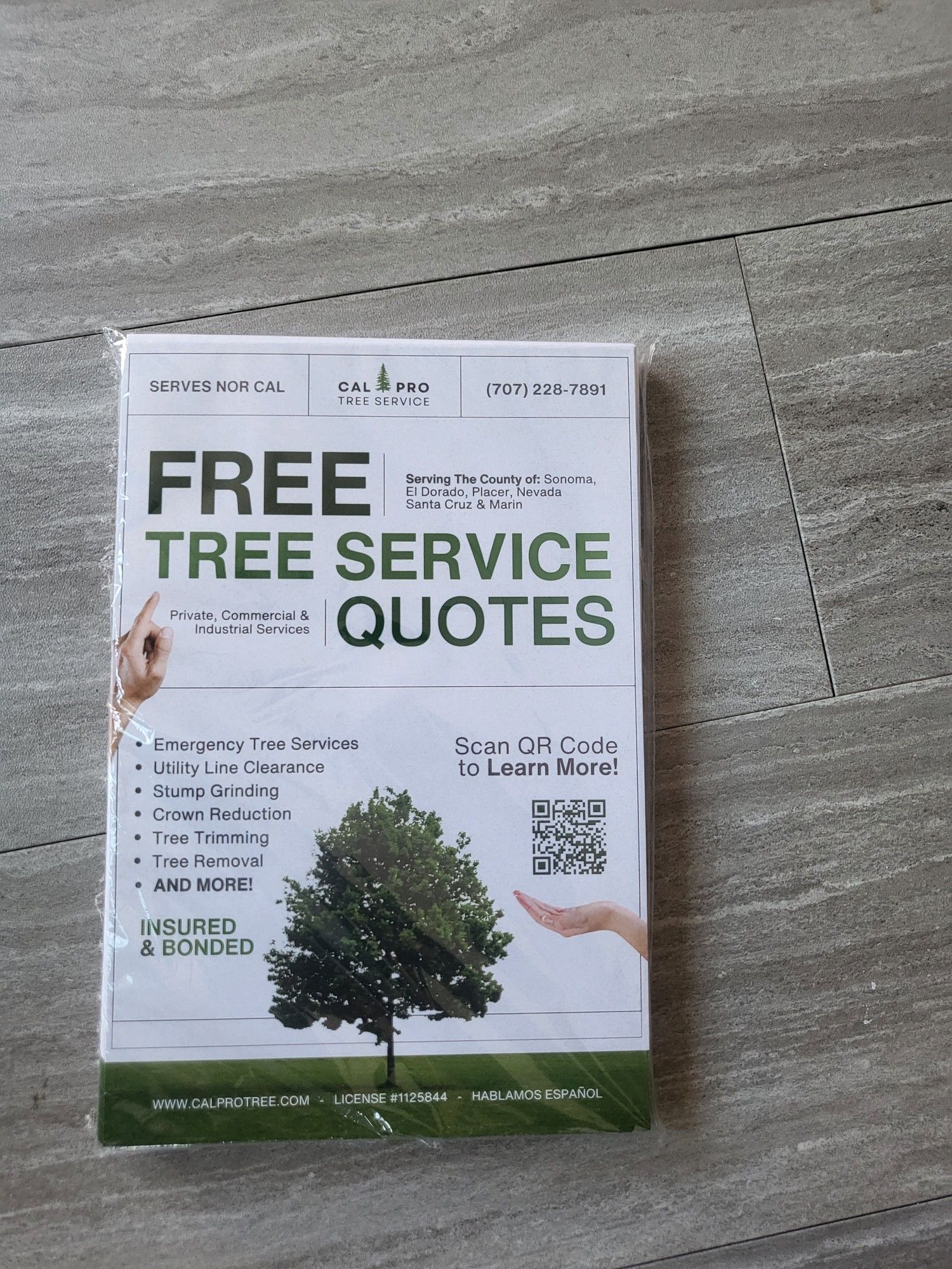 A book titled free tree service quotes is sitting on a table.