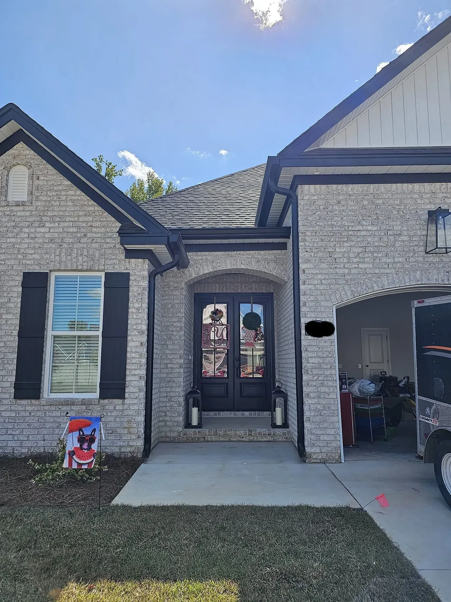 A white brick house with black shutters and a black door.