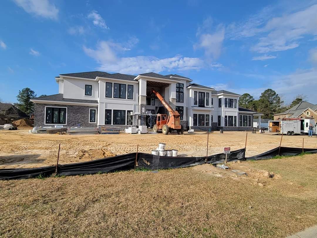 A large house is being built in a field.