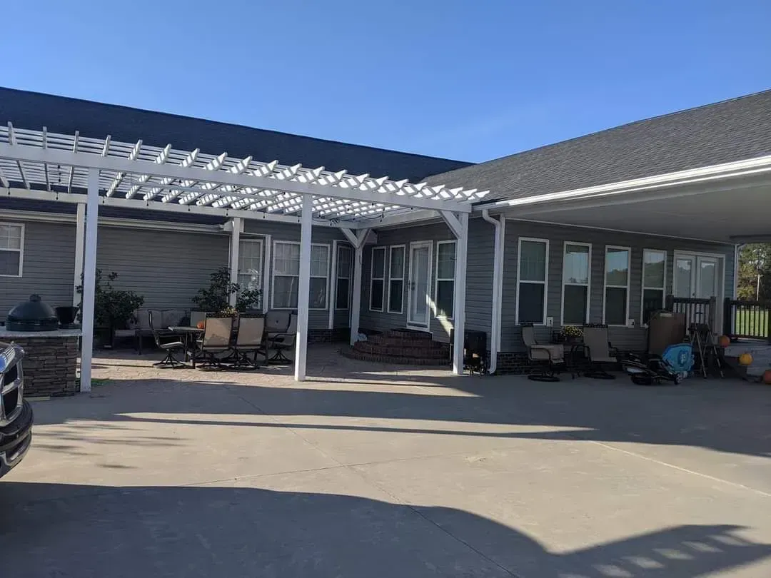 A large house with a covered porch and a truck parked in front of it.