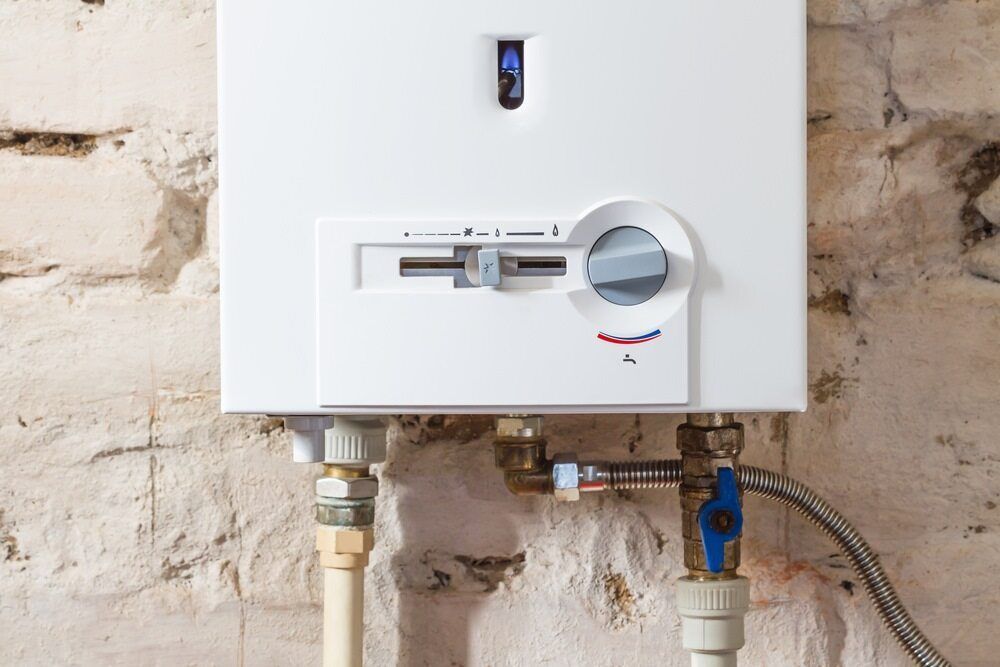 A White Water Heater is Attached to a Brick Wall — Dave's Plumbing and Gasfitting in Maroochydore, QLD
