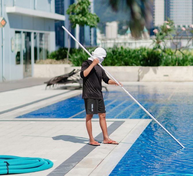 Essential pool maintenance tools and equipment laid out on the deck.