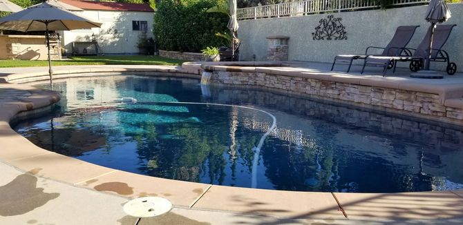 Technician performing professional swimming pool repairs and inspection.