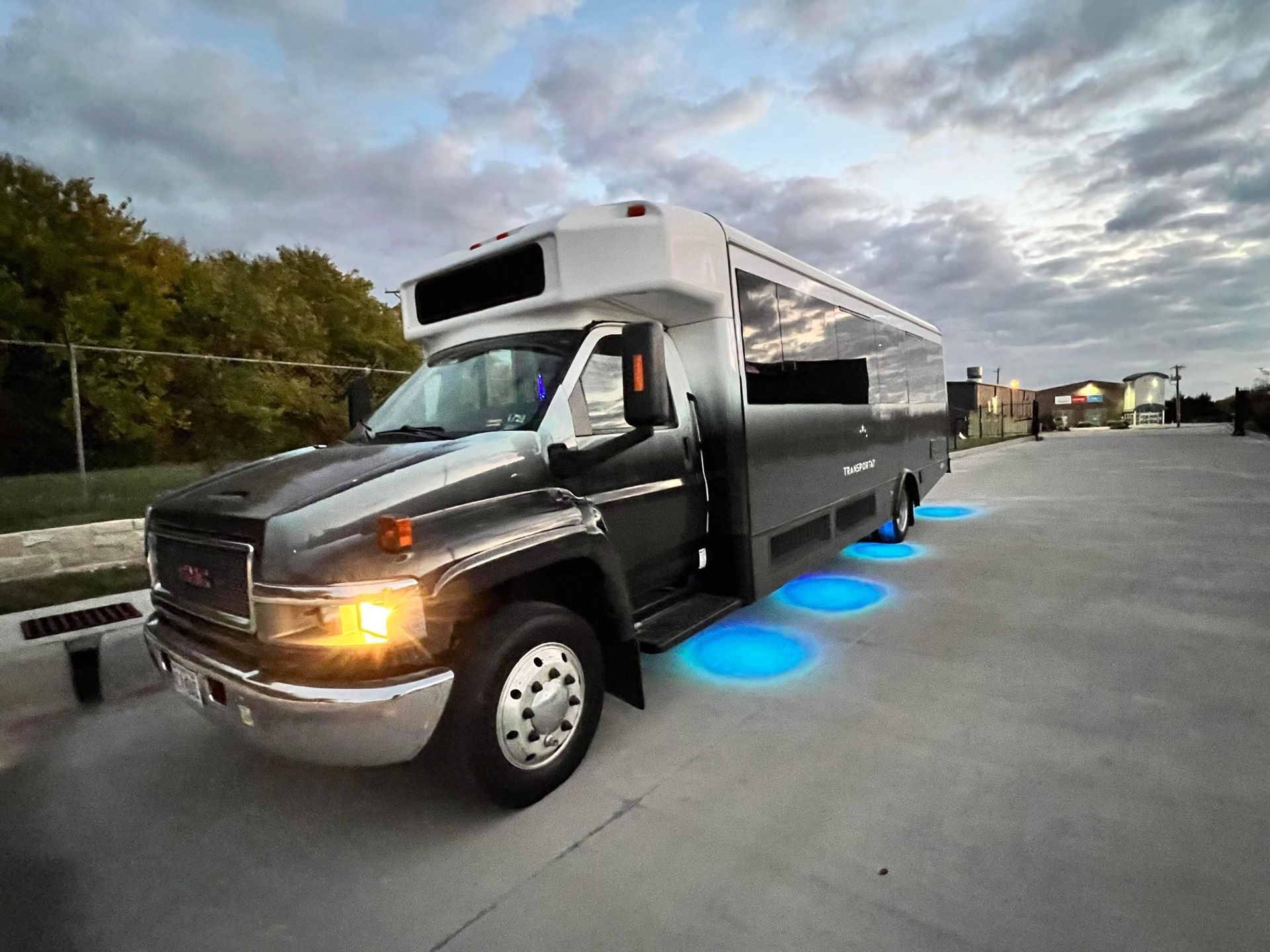 A large shuttle bus is parked in a parking lot.