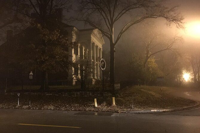 A foggy night with a building in the background and a street light in the foreground.