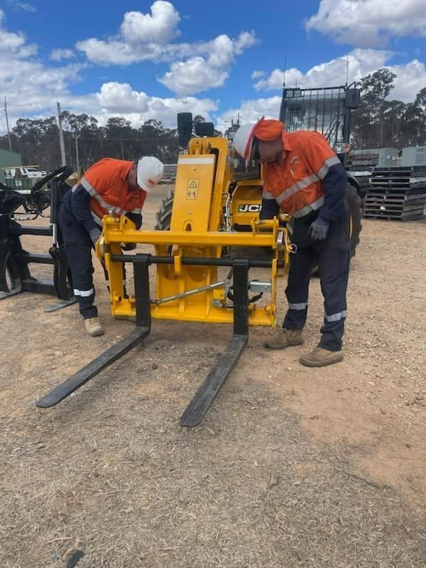 Two Worker Holding Tractor Attachment — Statement of Attainment Central Coast