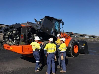Group of Men Talking Beside a Bulldozer — Plant Operator Courses Maitland