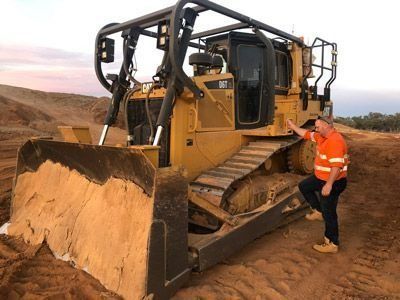 Worker Standing Beside Large Bulldozer — Verification of Competency Port Stephens
