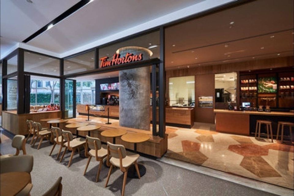 Tim Hortons cafe interior with seating, counter, and entrance. Beige and brown tones.