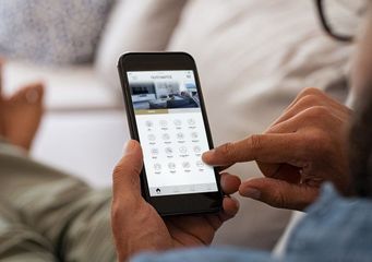 A person is sitting on a couch using a tablet computer.
