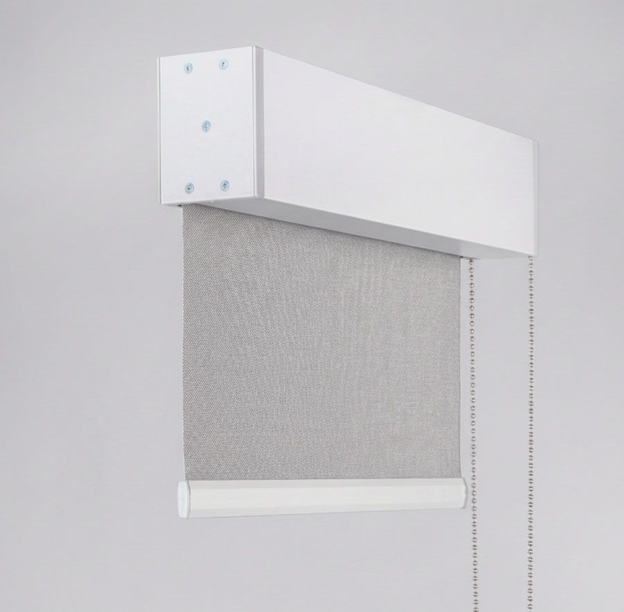 White window shade with fabric roll in a white valance, viewed at an angle.