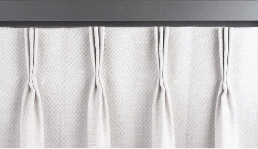 Light gray pleated curtains hanging from a dark gray track.