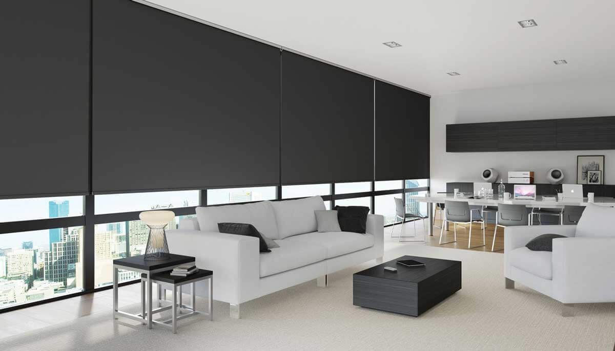 A living room with a white couch and black blinds