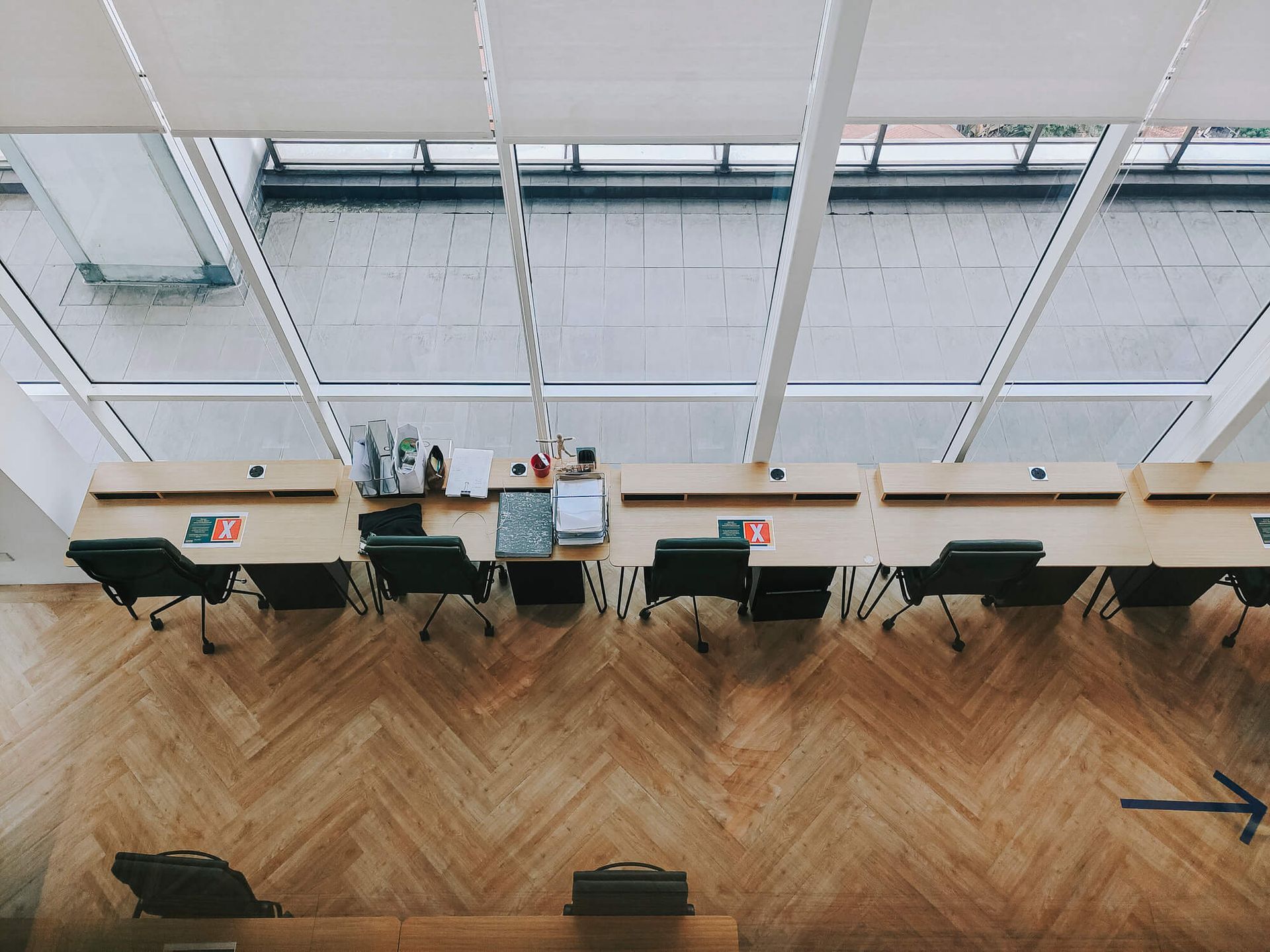 An aerial view of a row of desks and chairs in an office.