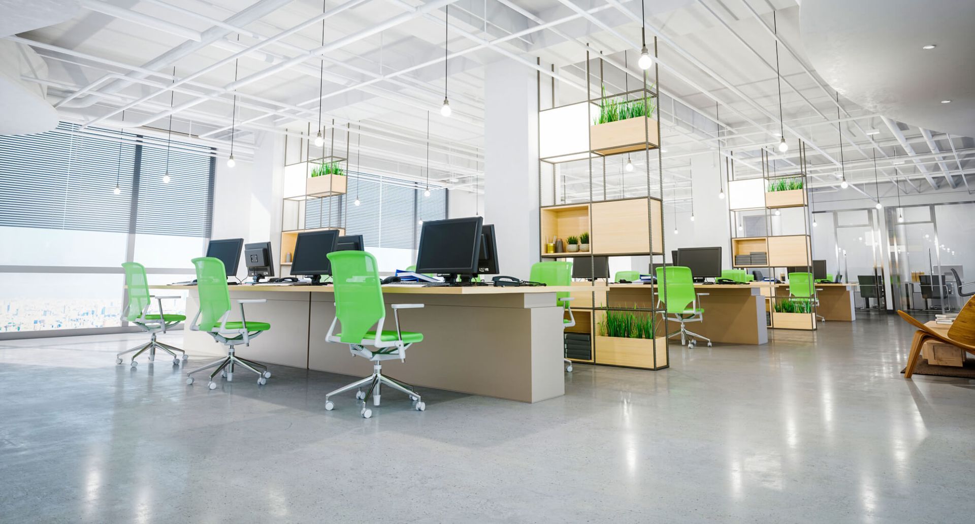 An empty office with green chairs , tables and computers.