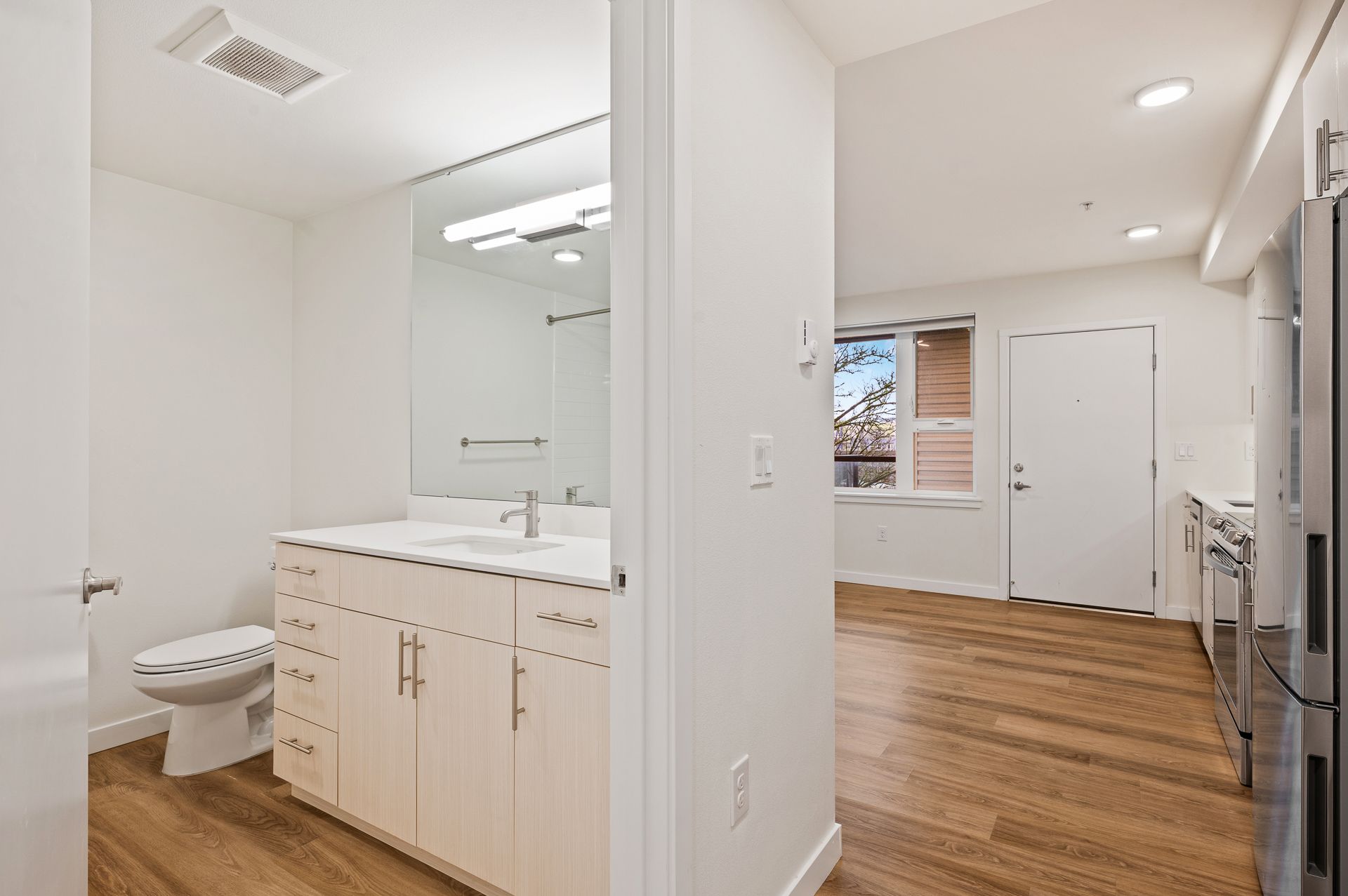 Photo of a bathroom, showing the living room in the background