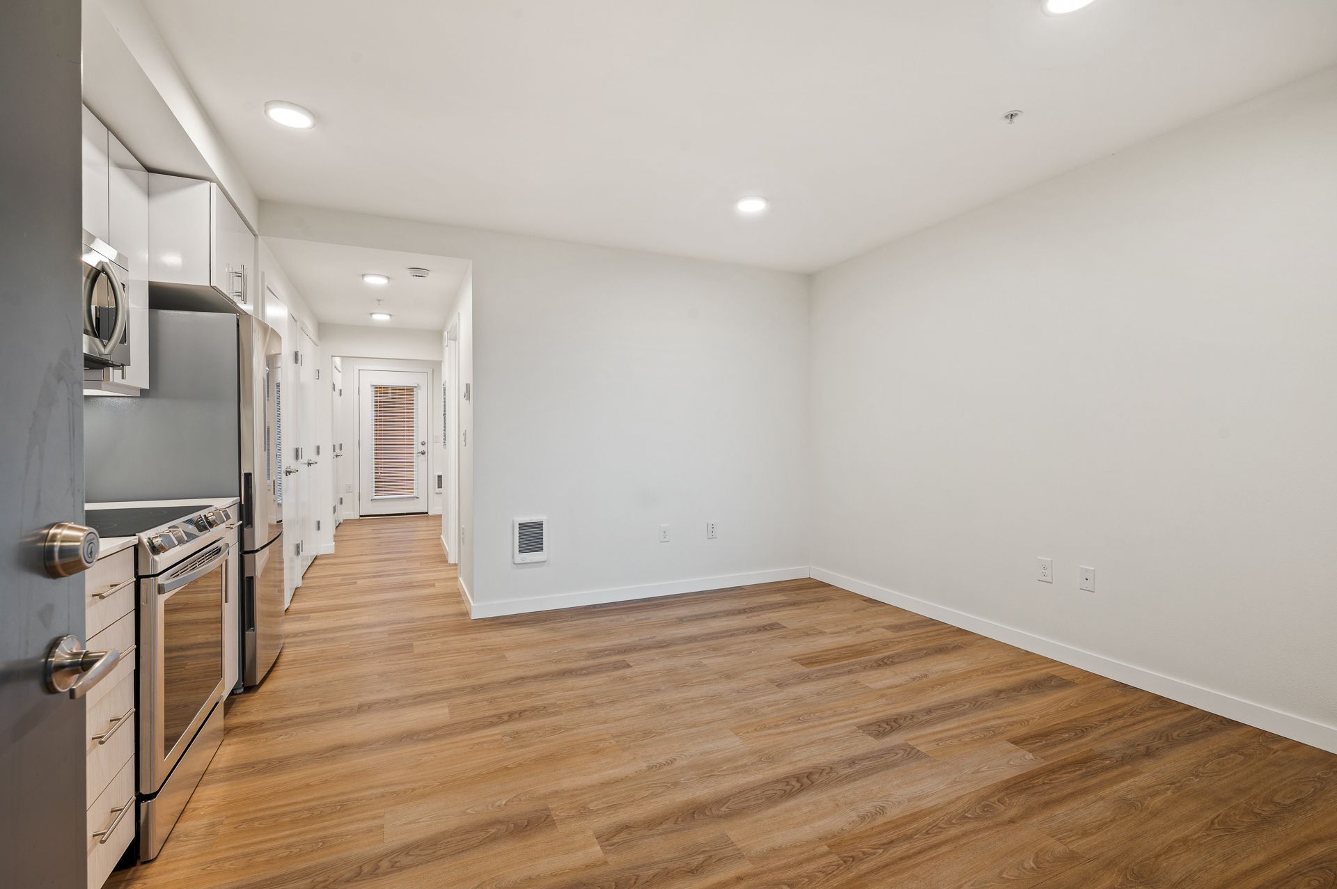 Photo of a kitchen and dining area with the unit entrance seen in the background
