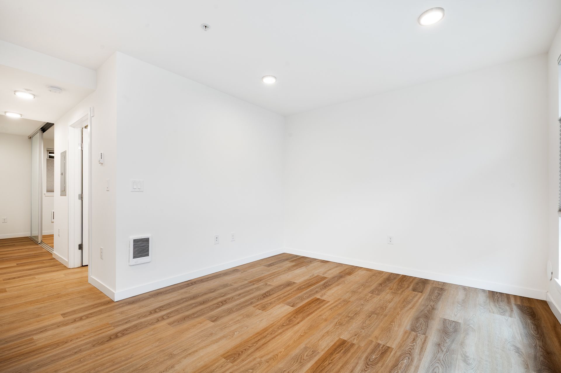 Photo of a living room with plenty of natural lighting and new flooring