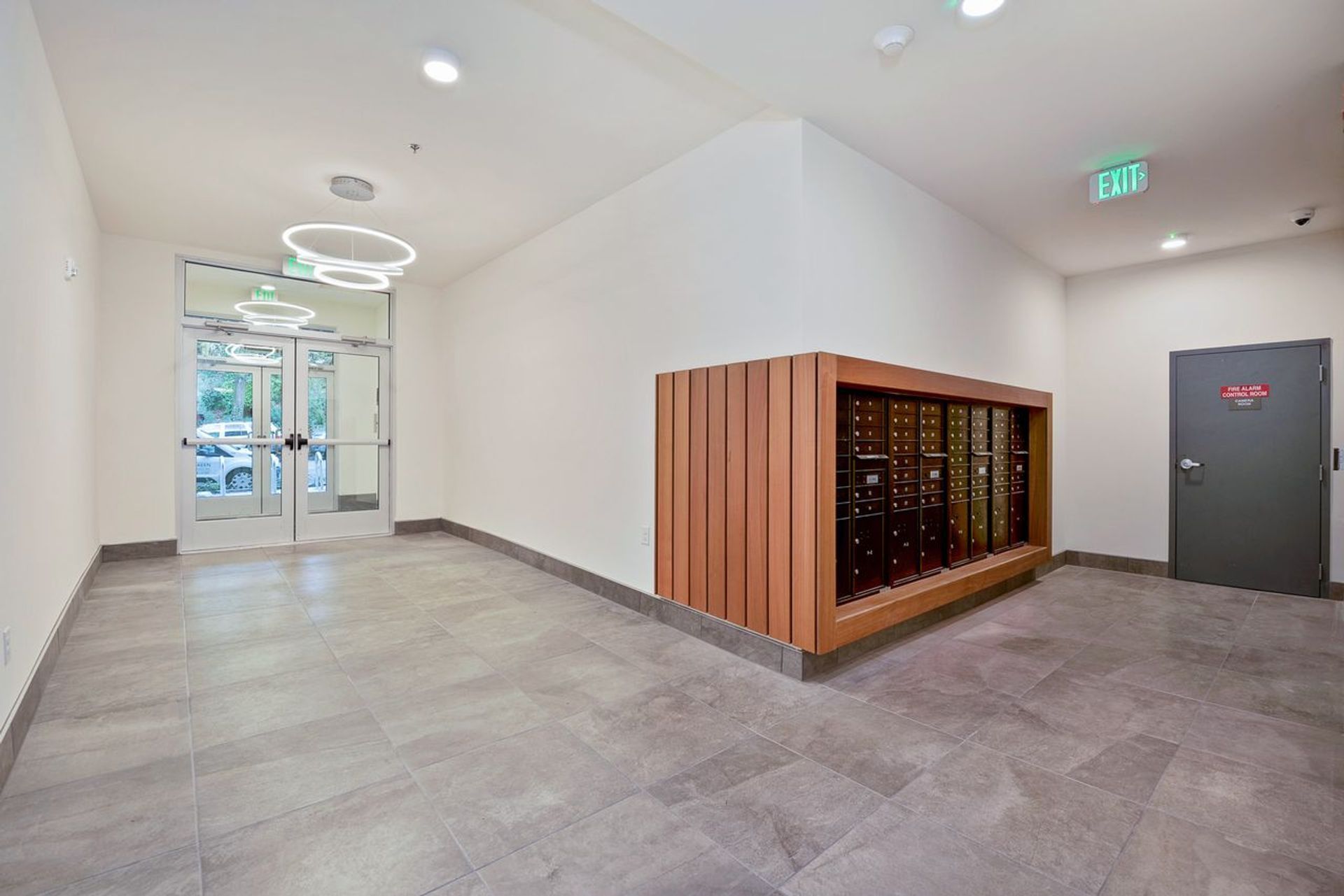 Wide entrance to an apartment building with mailboxes on the side of the photo