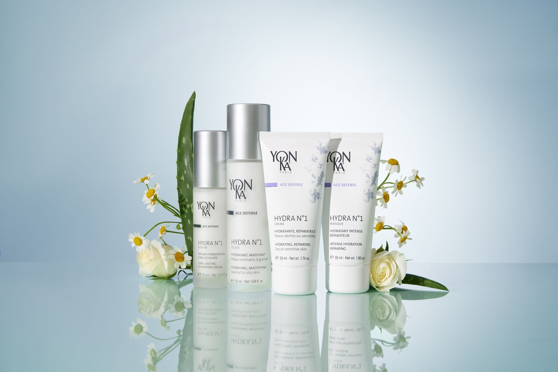 Spa scene: Stacked white towels, candles, flowers, beauty products on wood table, beige background.