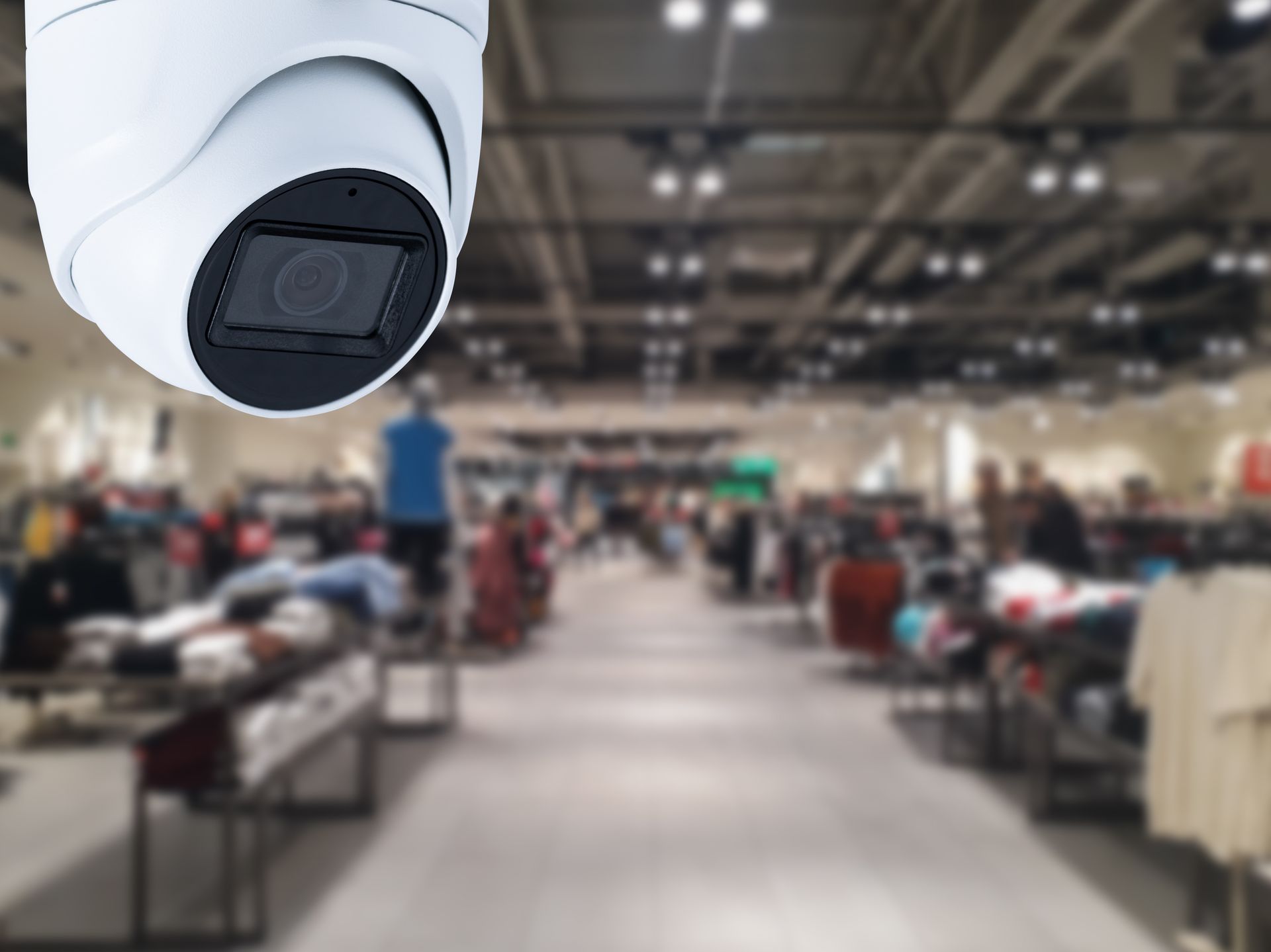 Advanced surveillance system monitoring clothing racks in a bright commercial store.
