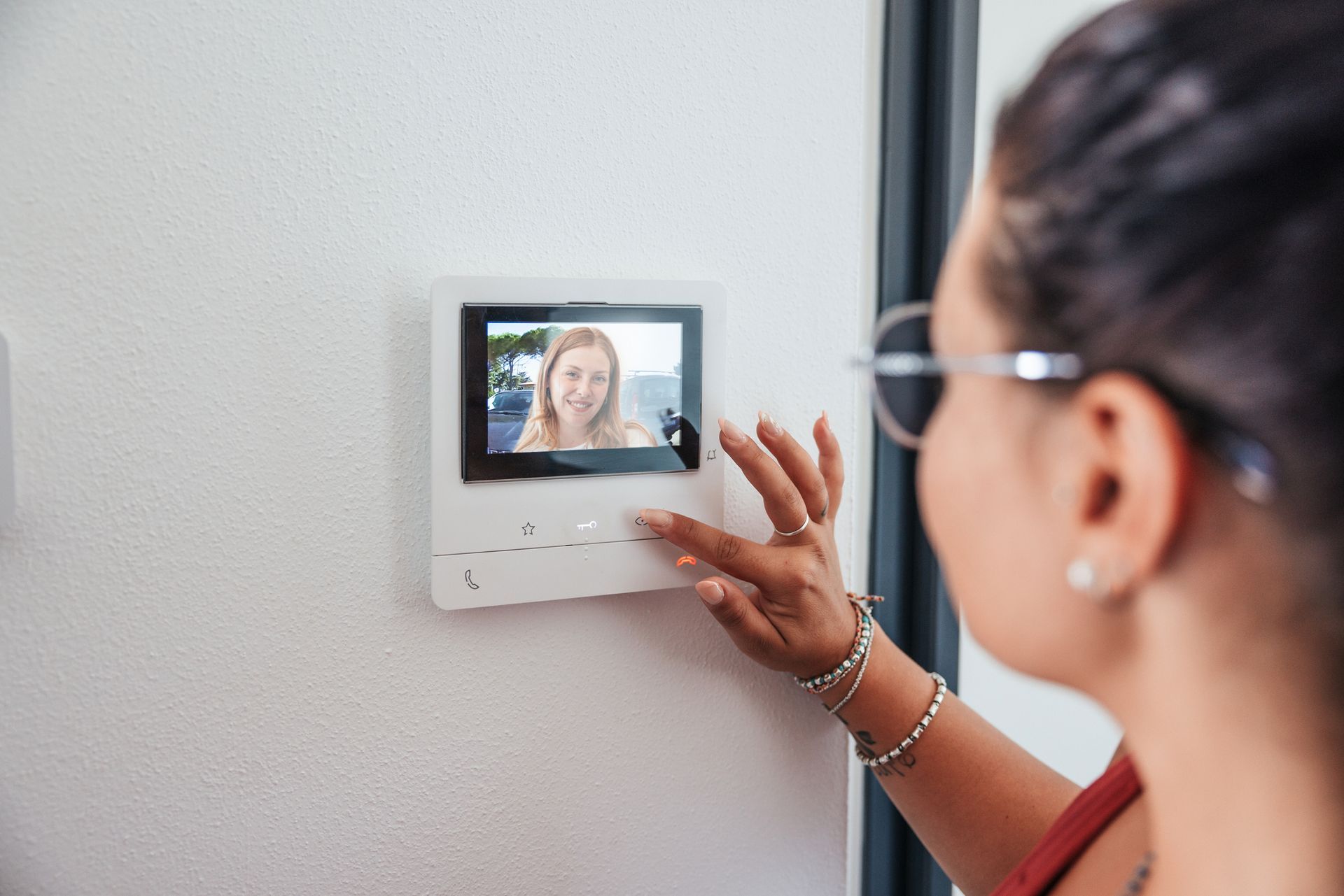 A woman is talking on a video doorbell.