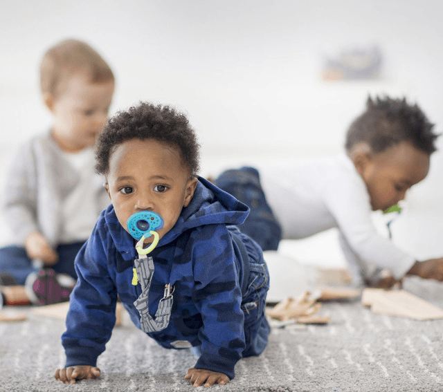 baby boy wearing jackets and jeans with baby pacifier