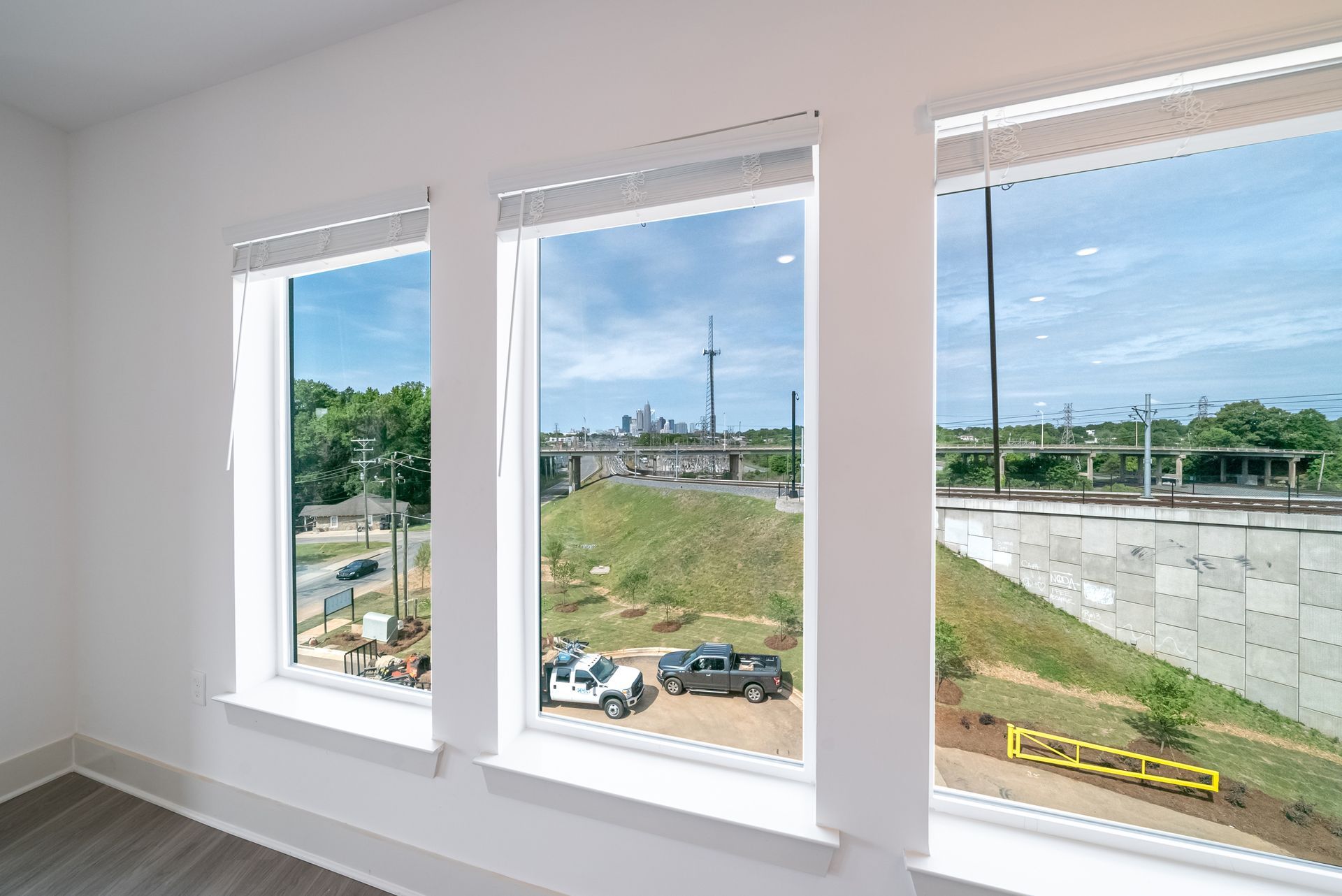 Modern kitchen with island, stainless steel appliances, white cabinets, and large windows.