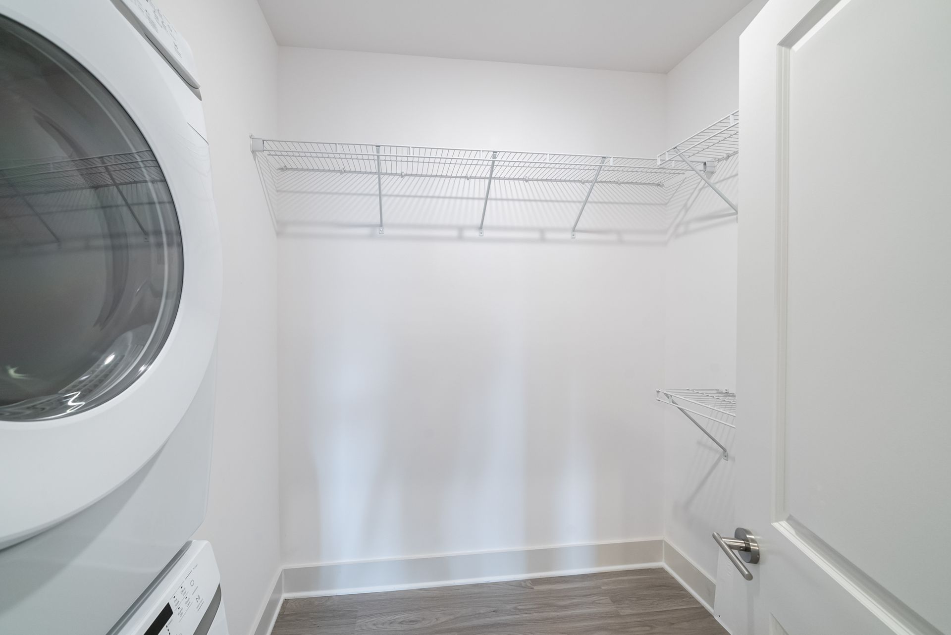 Laundry room with a washer, shelving, and folding drying rack.