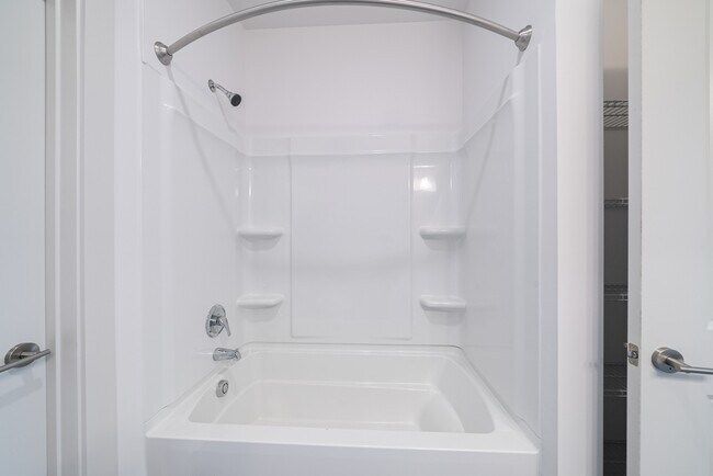 White bathroom with a bathtub and shower.