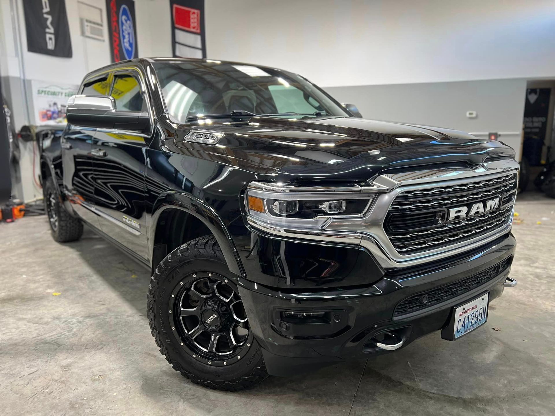 A black ram 1500 truck is parked in a garage.