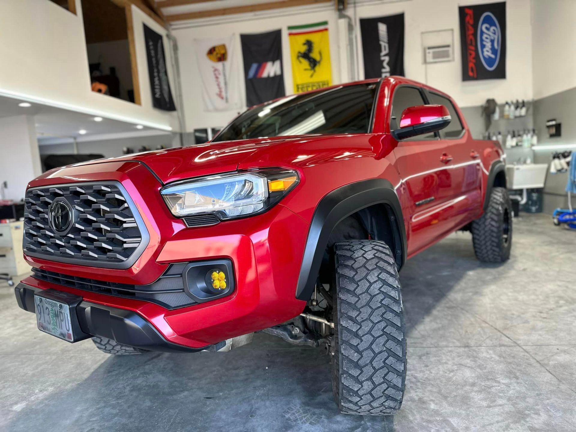 A red toyota tacoma is parked in a garage.