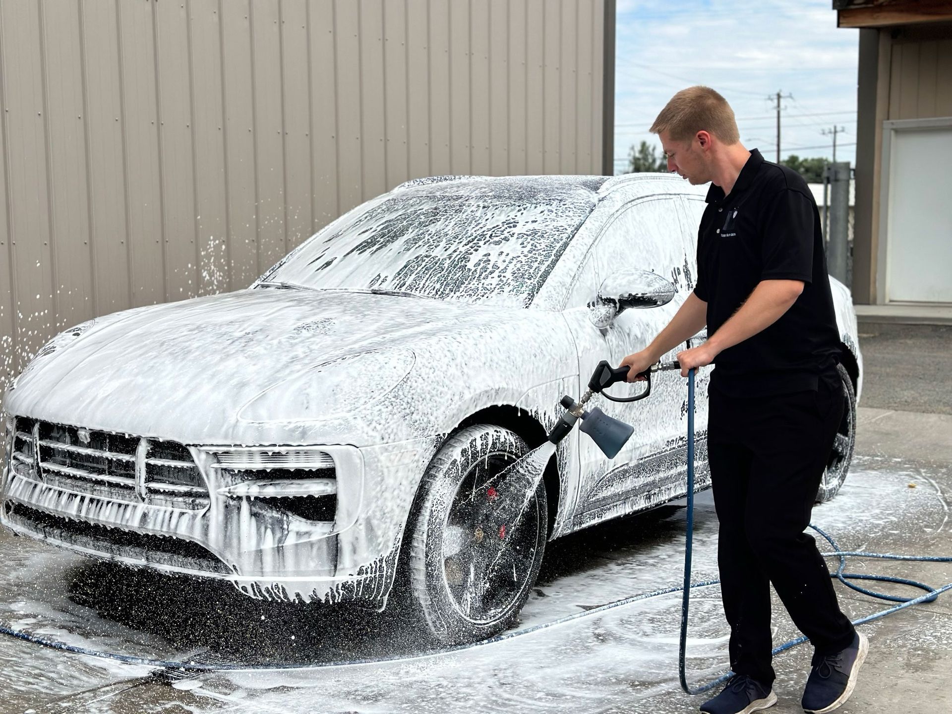 A man is washing a car with foam.