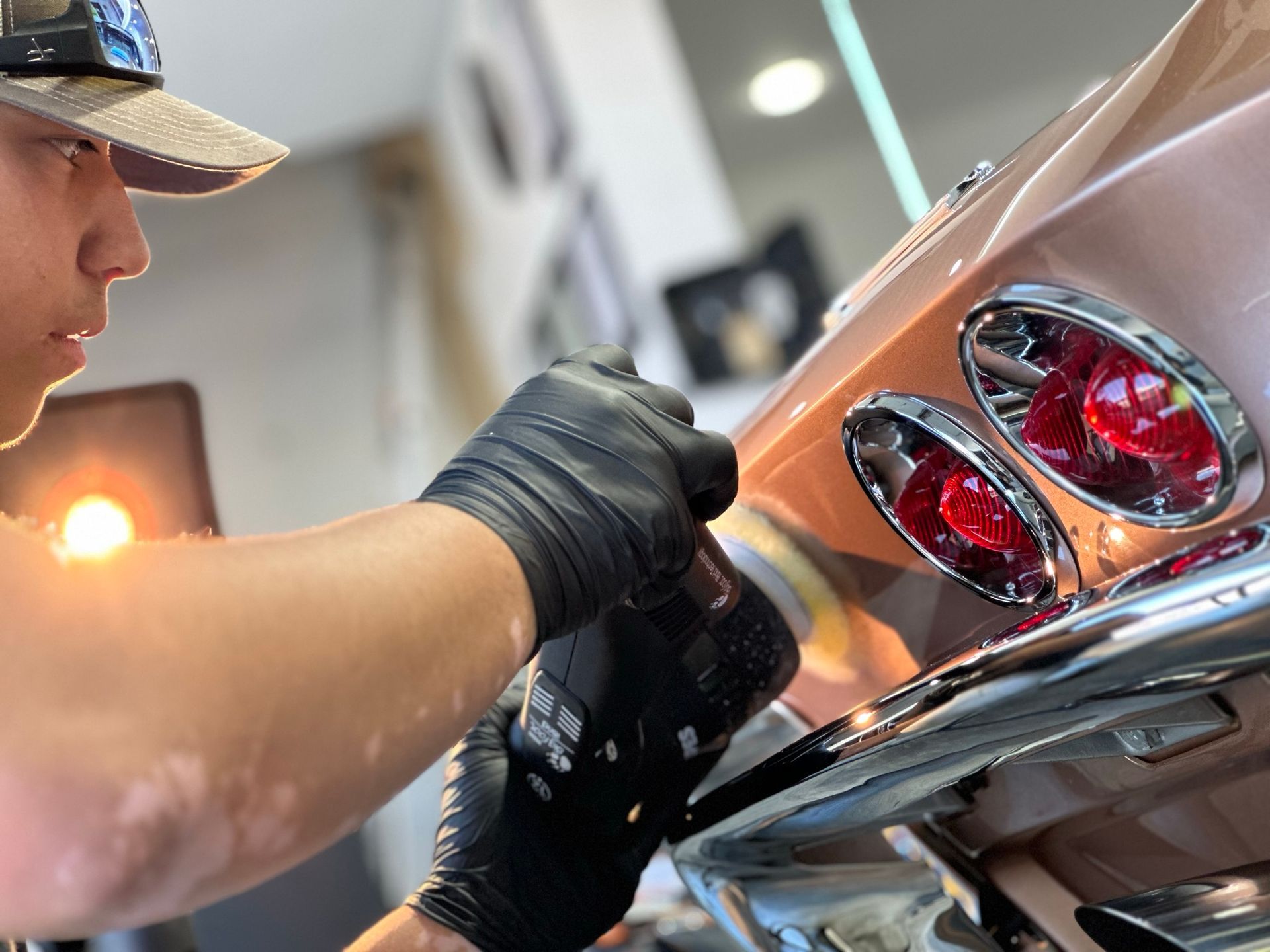 A man wearing black gloves is working on a car