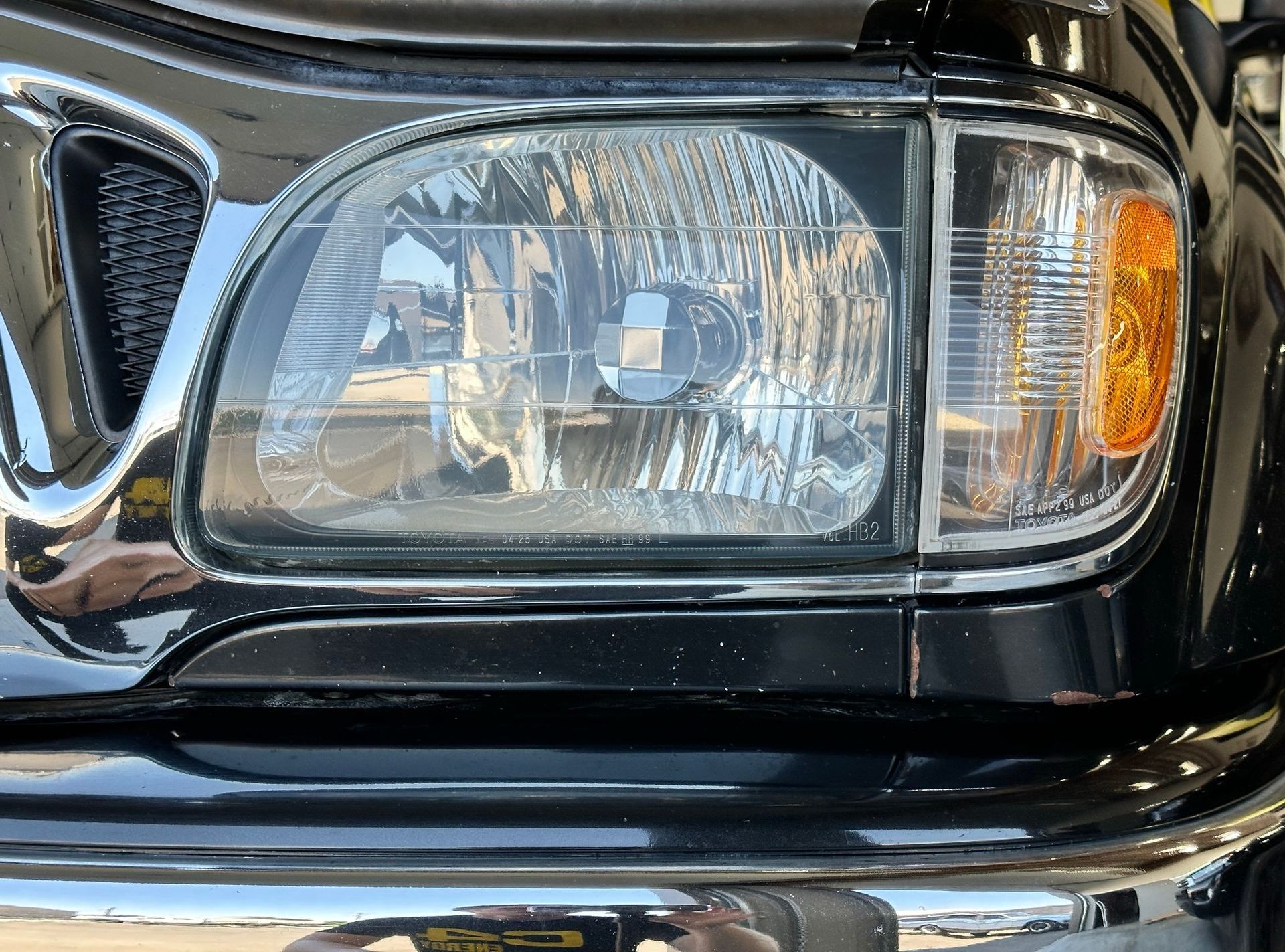 A close up of a black car 's headlight.