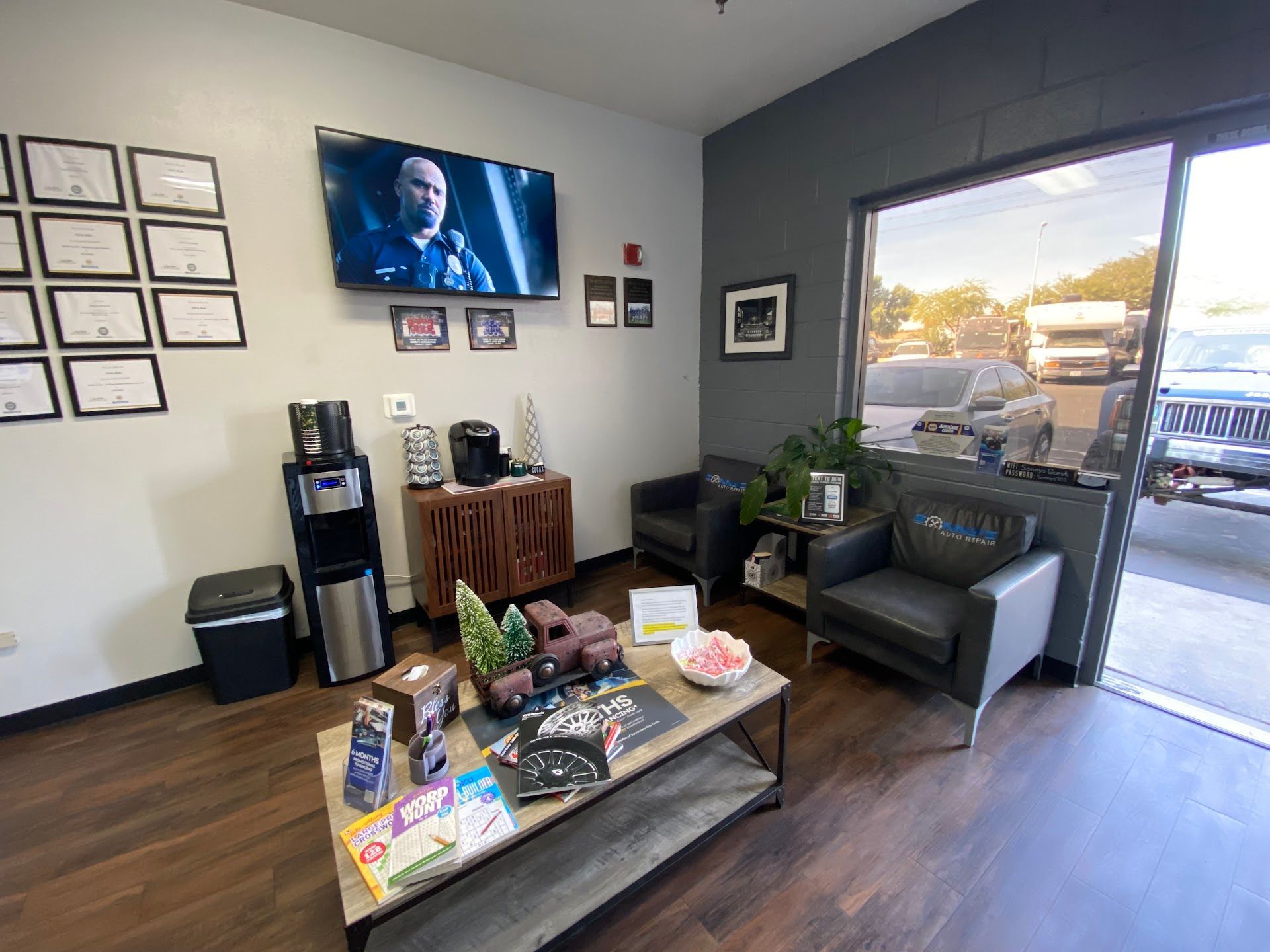 Waiting area: chairs, coffee station, TV showing a man | Sonny's Auto Repair