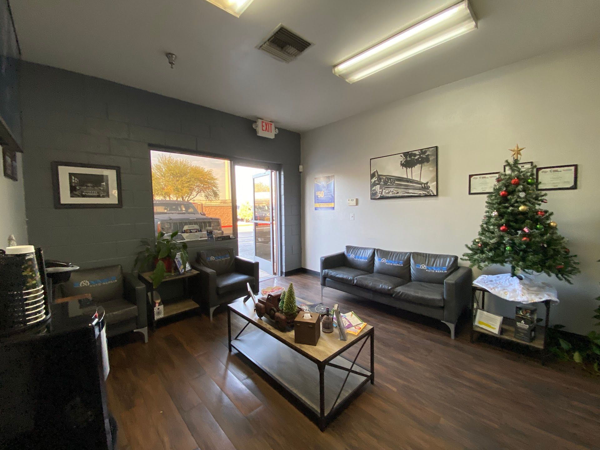 A waiting room with dark grey walls, leather furniture | Sonny's Auto Repair