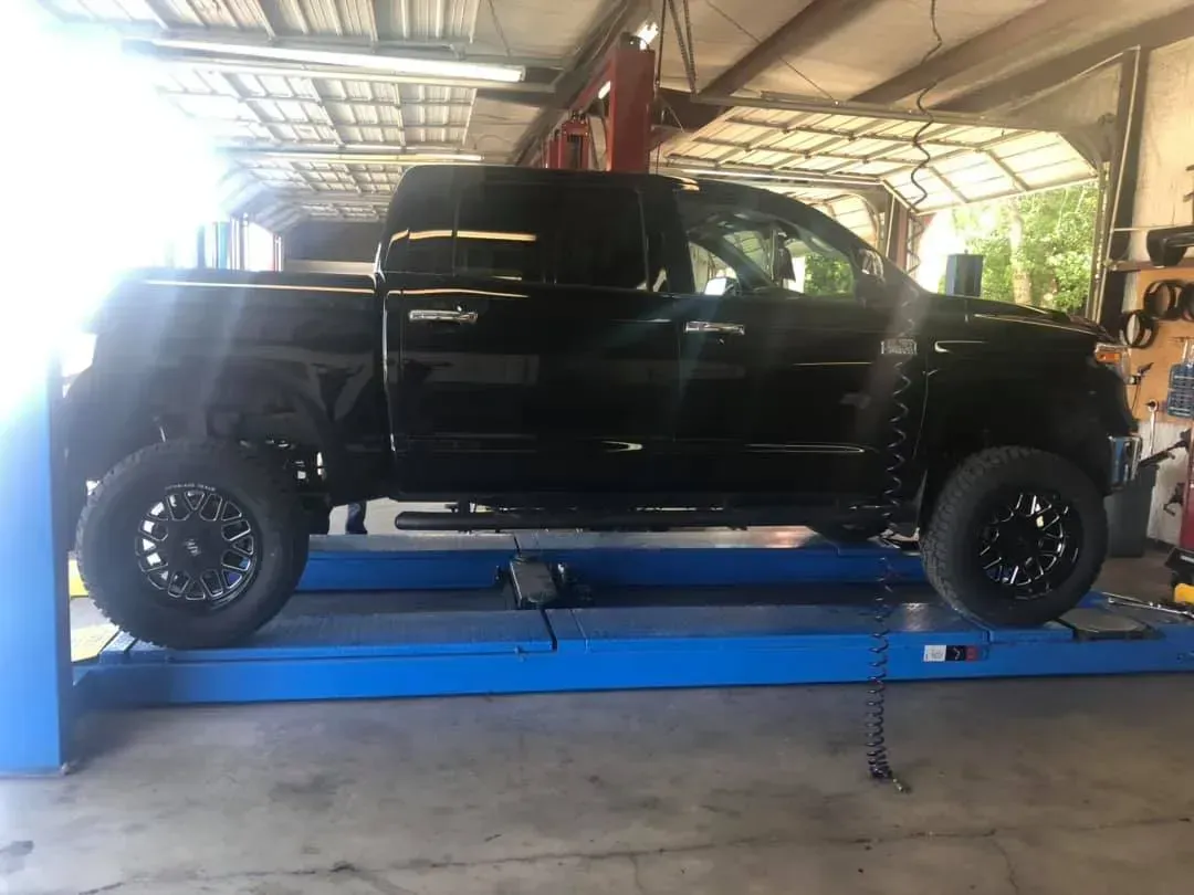 Black Truck On a Lift — Killeen, TX — Alignment & Brakes Specialist