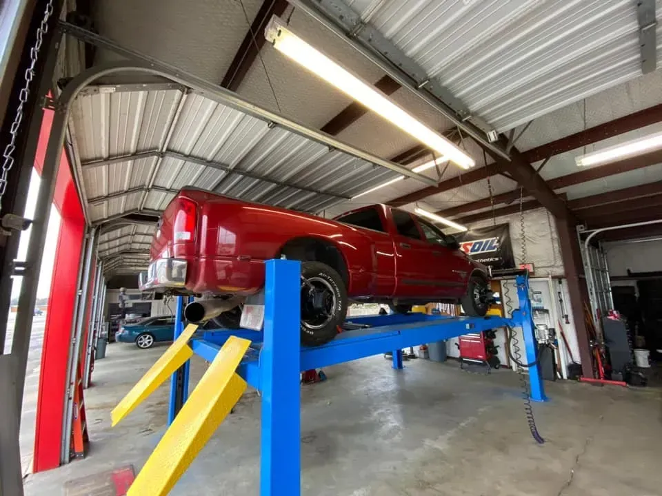 Red Truck on a Blue Lift — Killeen, TX — Alignment & Brakes Specialist