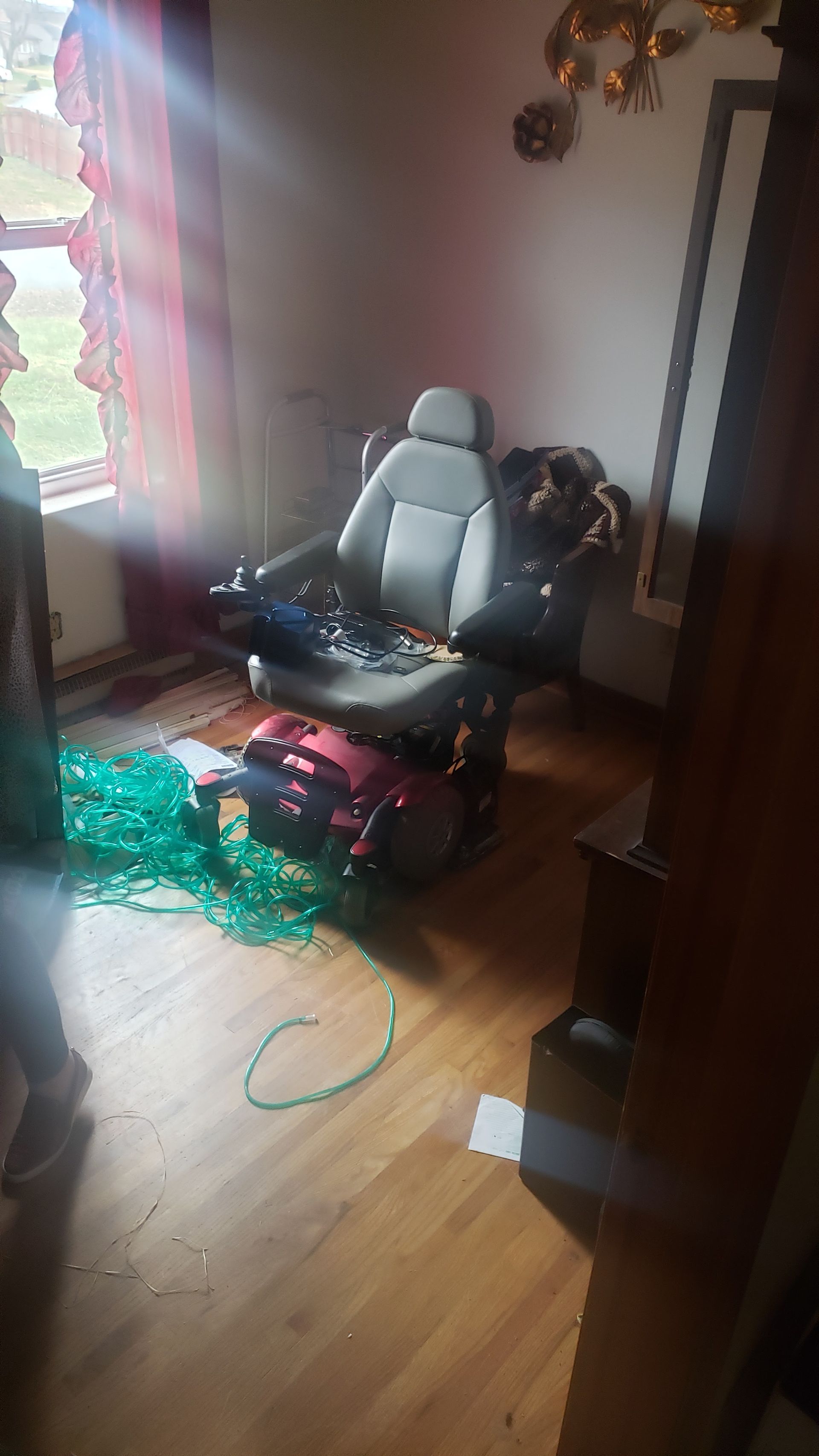 A room with a chair and a scooter on the floor.