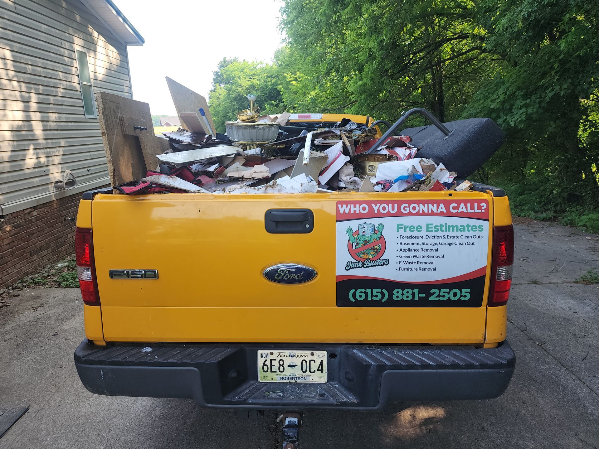 Yellow truck bed filled with debris, license plate 