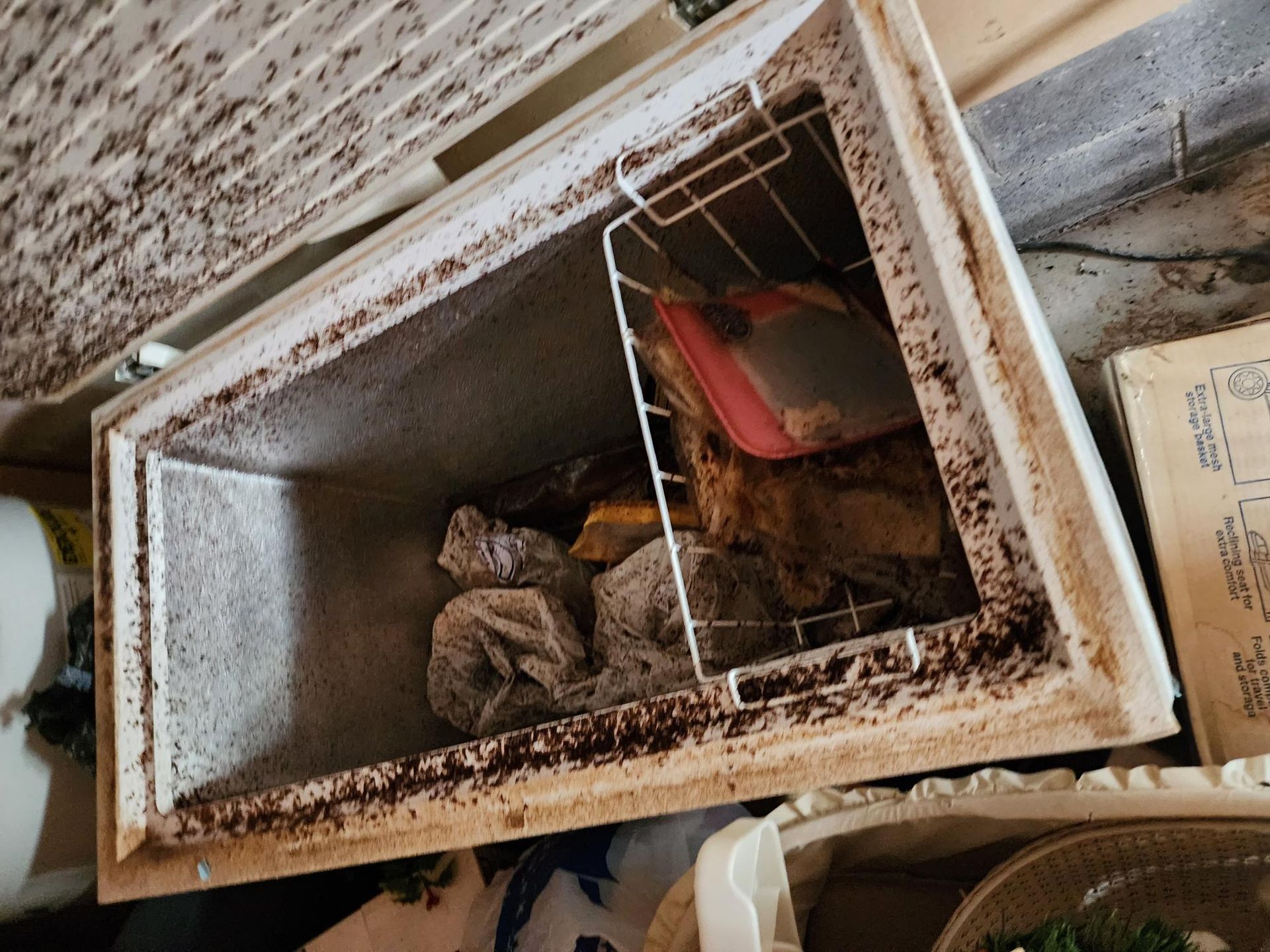 A dirty freezer is sitting on top of a table.
