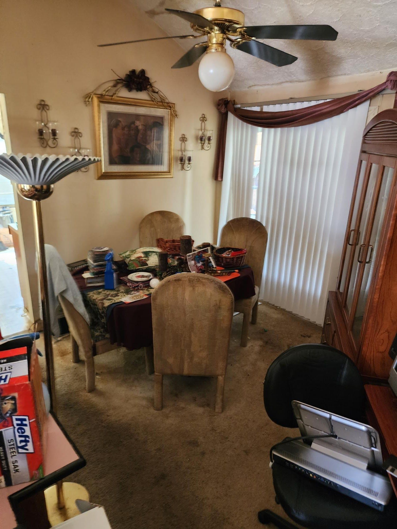 A dining room with a table and chairs and a ceiling fan
