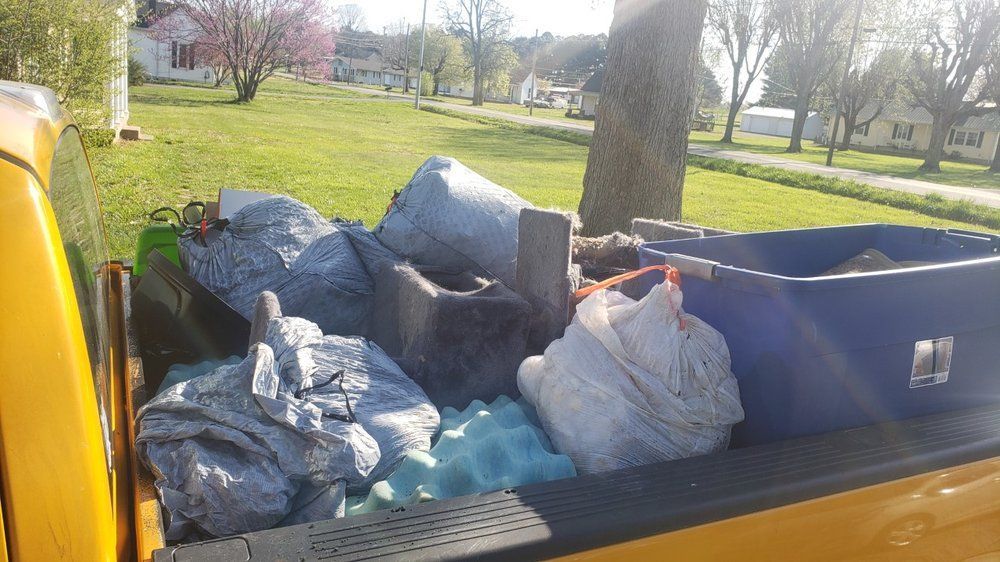 A yellow truck is filled with a lot of trash.