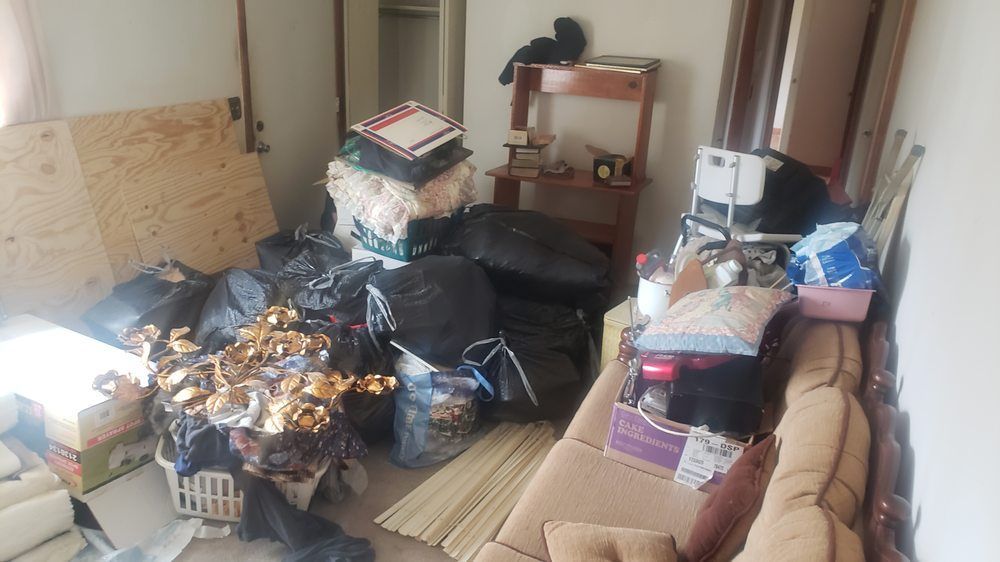 A living room filled with lots of trash bags and a couch.