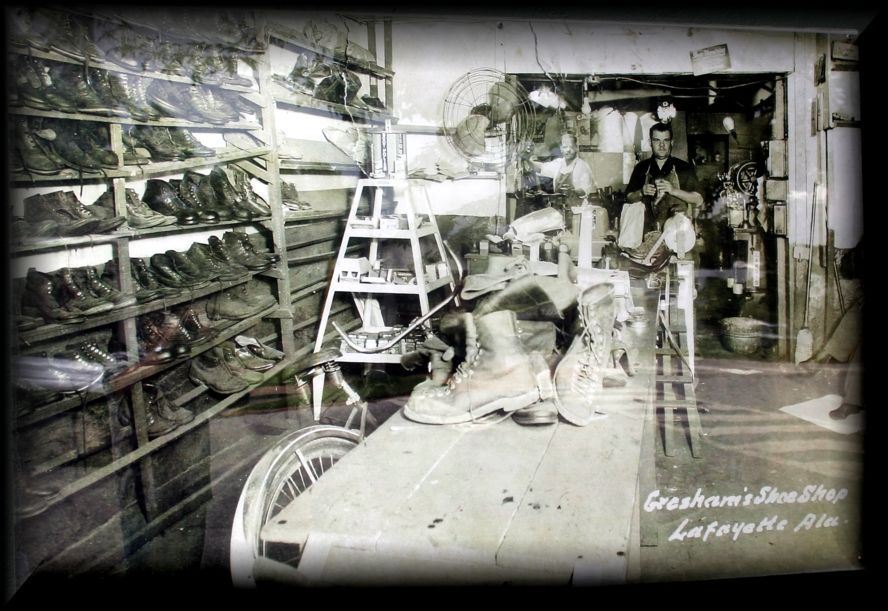 A black-and-white photo of Graham's Shoe Shop in Lafayette, Alabama, showing shelves of boots and a work table.